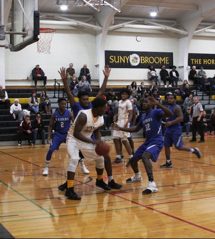 SUNY Broome men's basketball player surrounded by FM players under basket