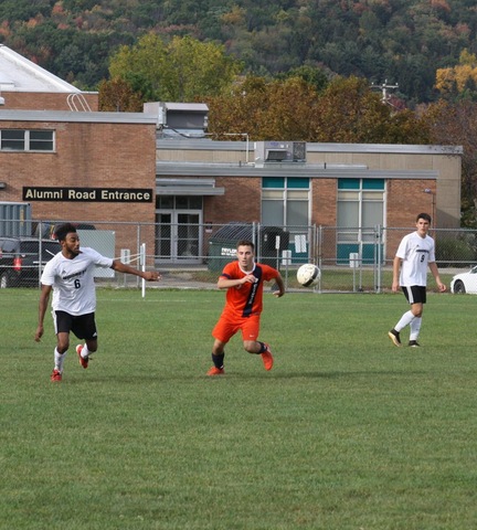SUNY Broome men's soccer player and opponent chasing down ball