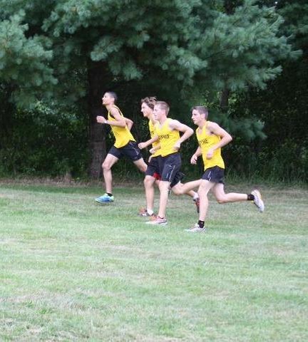 Men's cross country team running on side of hill