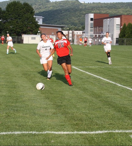 SUNY Broome women's soccer players chasing opponent and ball