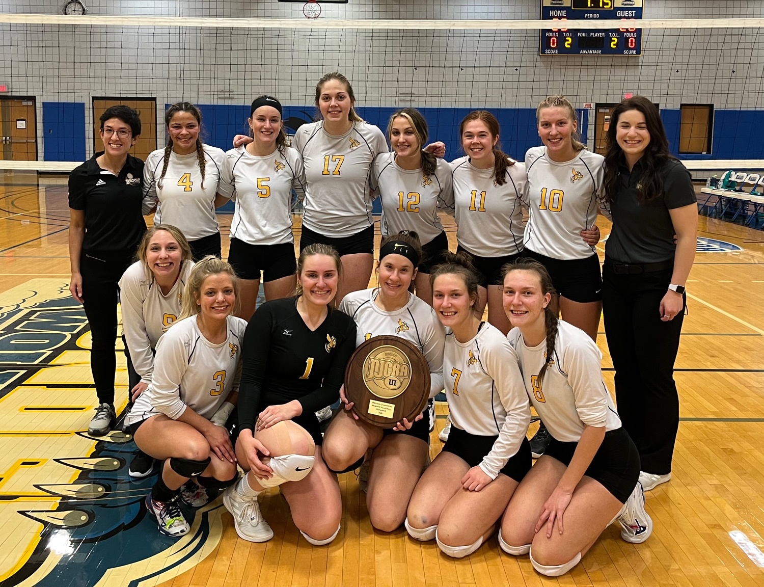 Volleyball team posing with Championship plaque