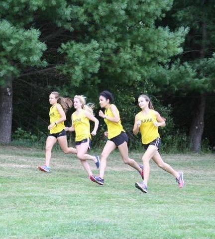 Women's cross country team running on side of hill