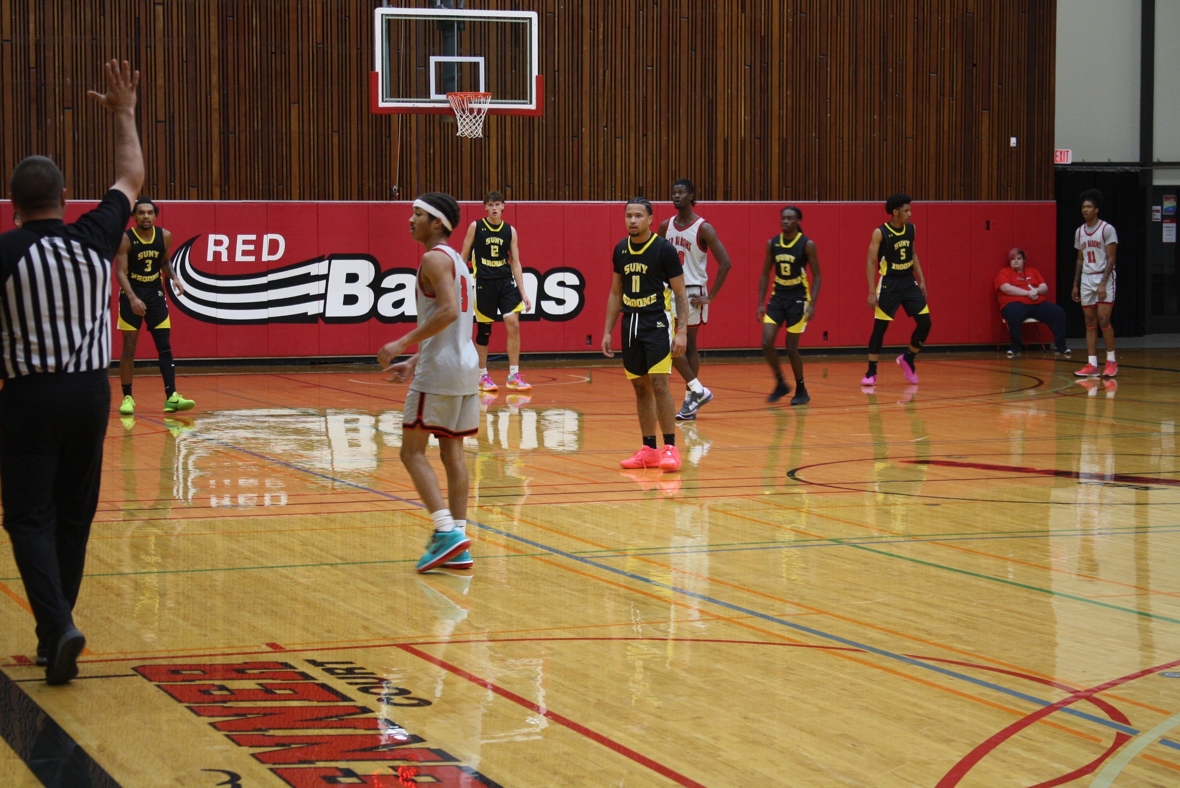 Referee calling a foul as players from each team on court look on