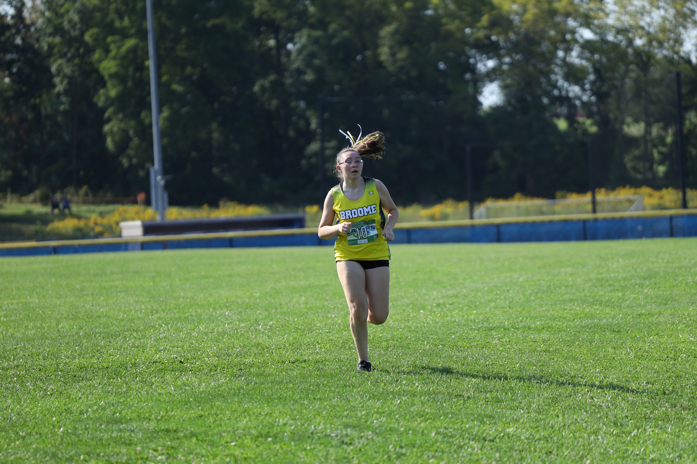 Broome women's cross country runner on the course